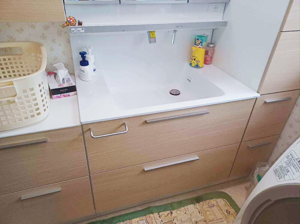施工後の洗面化粧台のお写真です。<br />
白い洗面器とナチュラルブラウンの引き出しが柔らかい印象を与え、開放感のある空間になりました。